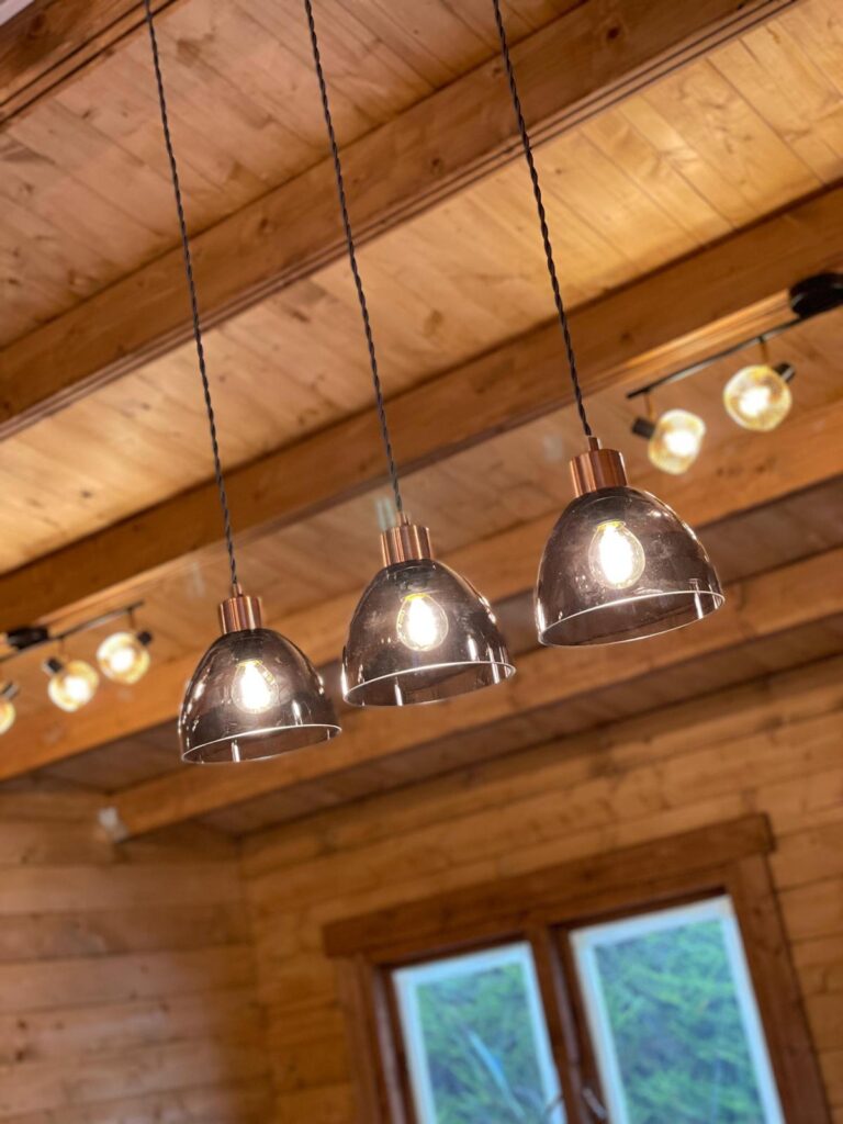 Three lamps hanging from wooden ceiling